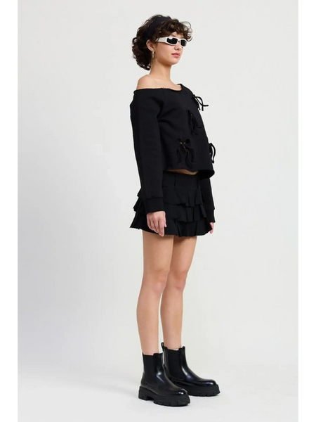 Emory Park black Off Shoulder Distressed Top paired with a black ruffled skirt and black ankle boots