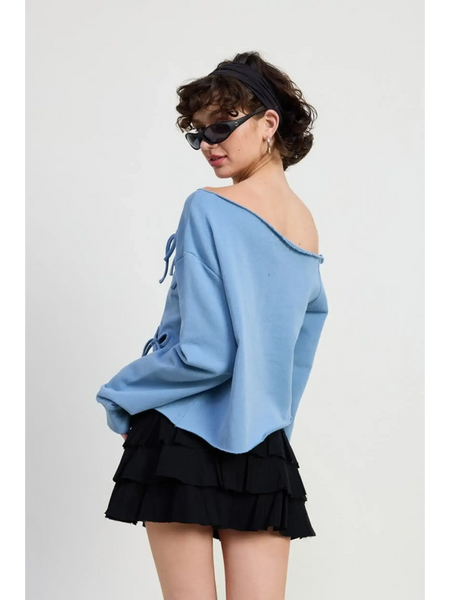 Emory Park Off Shoulder Distressed Top in blue worn by model with black ruffled skirt and sunglasses
