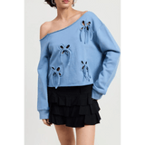 Emory Park off shoulder distressed top in blue with long sleeves and bow cutout details