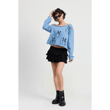 Emory Park Off Shoulder Distressed Top in blue worn with black ruffled skirt and black boots
