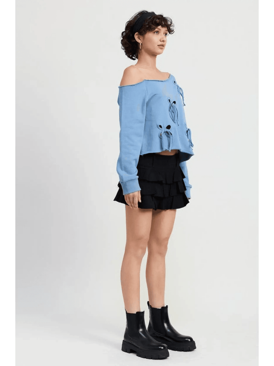 Emory Park Off Shoulder Distressed Top in blue with long sleeves worn with black layered skirt and black ankle boots