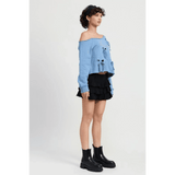 Emory Park Off Shoulder Distressed Top in blue with long sleeves worn with black layered skirt and black ankle boots