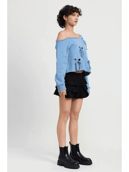 Emory Park Off Shoulder Distressed Top in blue with long sleeves worn with black layered skirt and black ankle boots