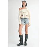 Emory Park Off Shoulder Distressed Top in cream with bow cutouts styled with denim shorts and black boots