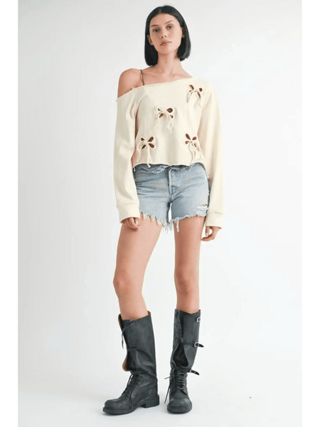 Emory Park Off Shoulder Distressed Top in cream with bow cutouts styled with denim shorts and black boots
