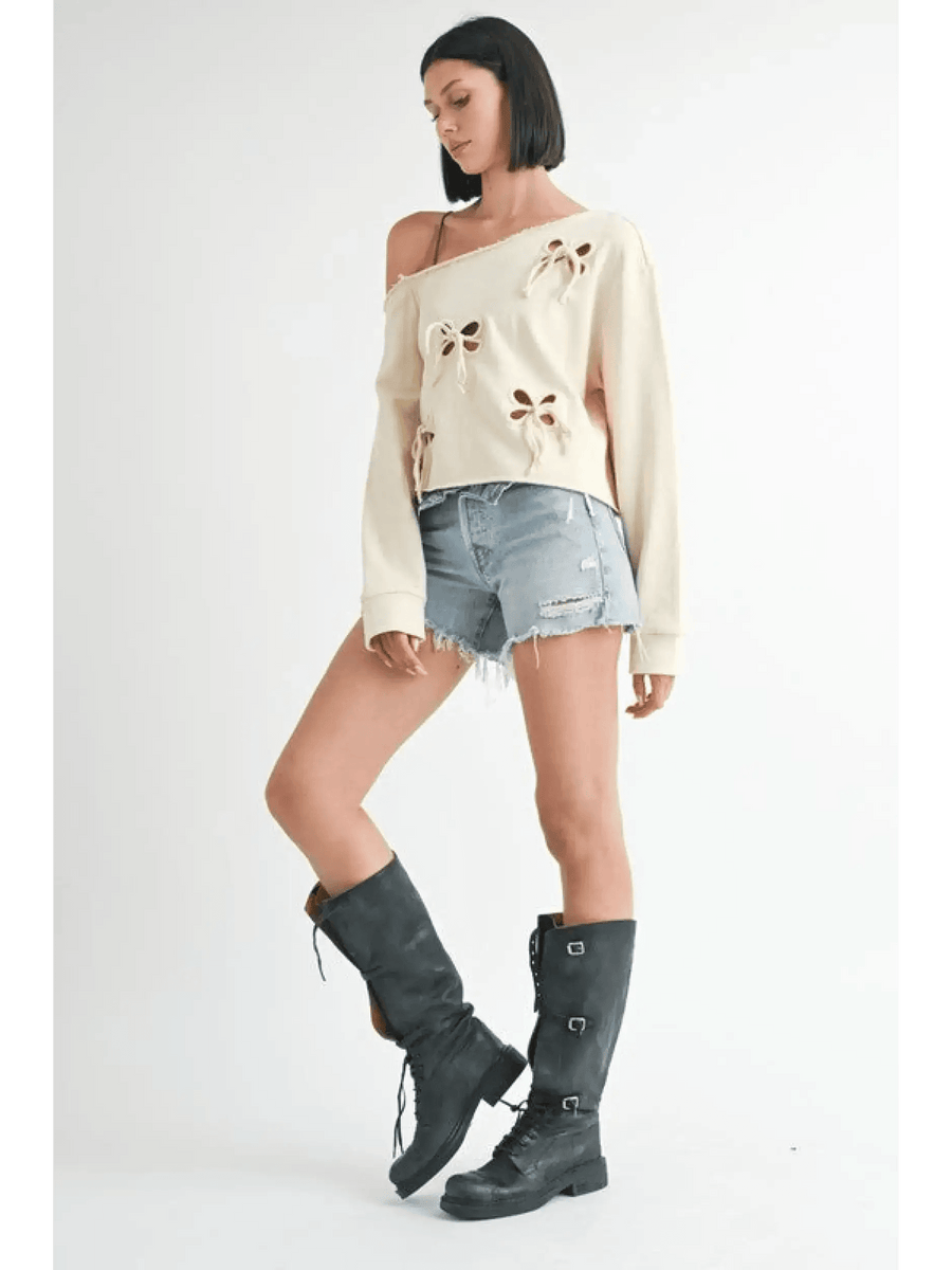 Emory Park Off Shoulder Distressed Top in cream worn with denim shorts and black boots