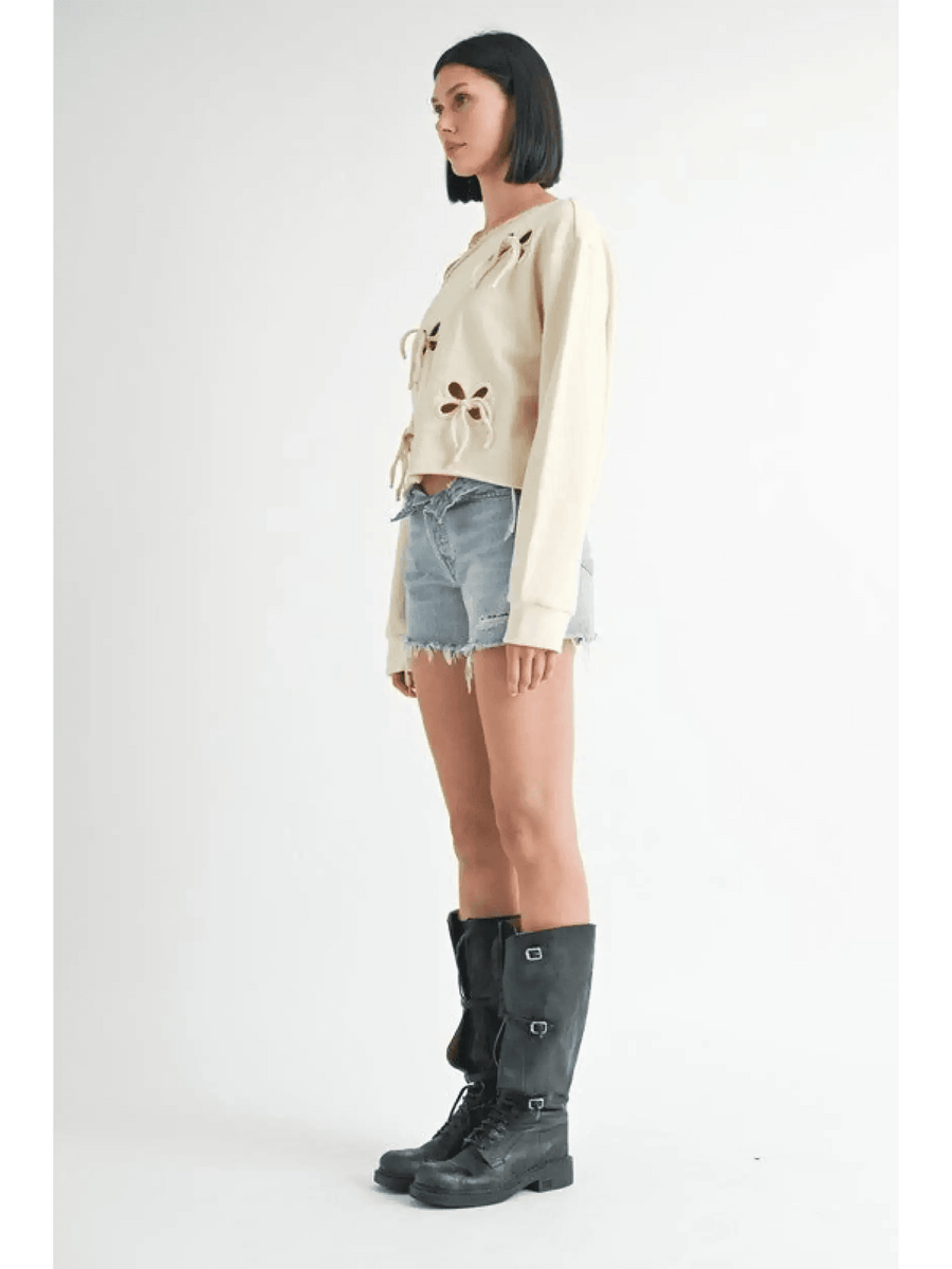 Emory Park off shoulder distressed top beige long sleeve paired with denim shorts and black boots