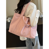 Lightweight Ladies duffle bag in pink corduroy fabric worn on shoulder by woman