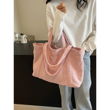 Lightweight Ladies duffle bag in soft pink corduroy fabric held by woman in casual white top and jeans