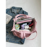 Lightweight ladies duffle bag in pink with multiple compartments, shown open with accessories inside