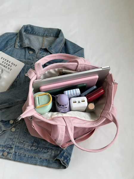Lightweight ladies duffle bag in pink with multiple compartments, shown open with accessories inside