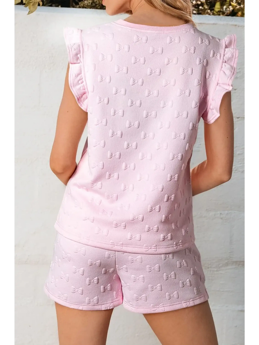 Back view of pink summer short set for women with bow pattern and ruffle sleeves