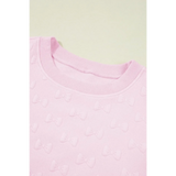 Close-up of pink summer short set for women featuring textured bow patterns on soft fabric