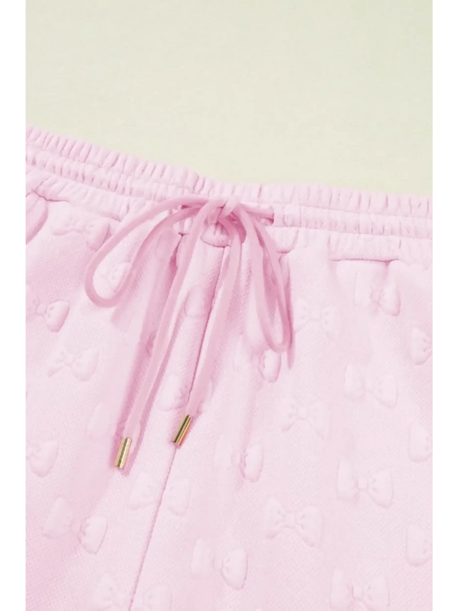 Close-up of pink summer short set for women by Trendsi with drawstring waistband and textured bow pattern