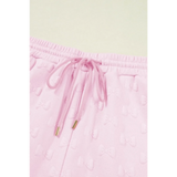 Close-up of pink summer short set for women by Trendsi with drawstring waistband and textured bow pattern