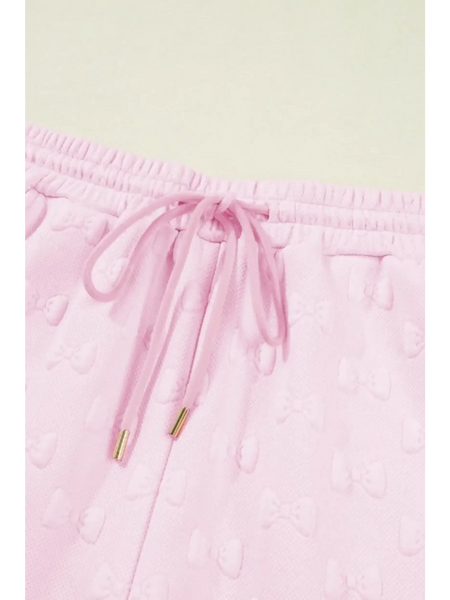 Close-up of pink summer short set for women by Trendsi with drawstring waistband and textured bow pattern