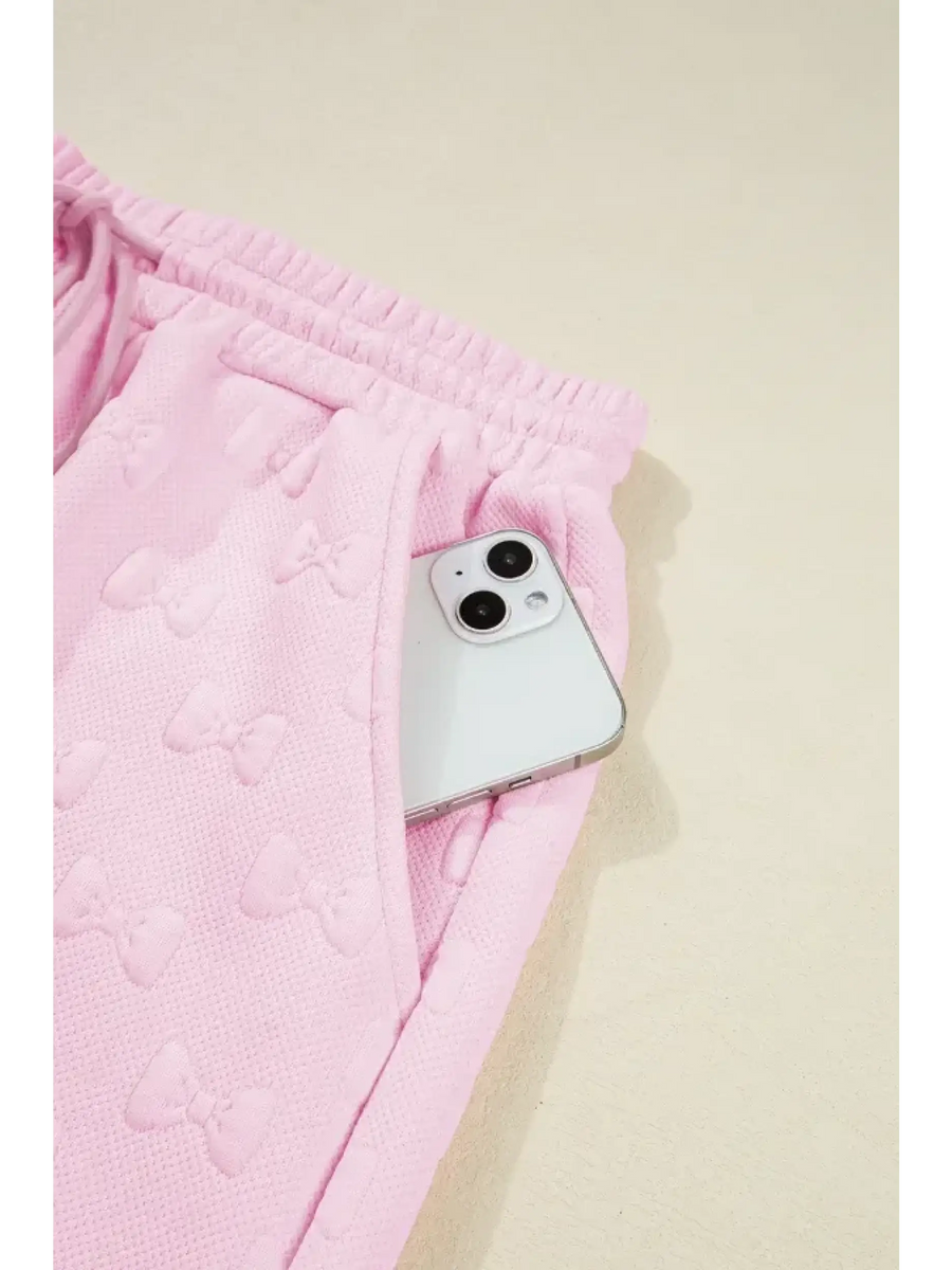 Pink summer short set for women by Trendsi featuring textured fabric and elastic waistband with side pocket holding a phone