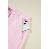 Pink summer short set for women by Trendsi featuring textured fabric and elastic waistband with side pocket holding a phone