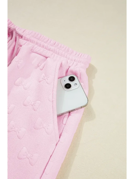 Pink summer short set for women by Trendsi featuring textured fabric and elastic waistband with side pocket holding a phone