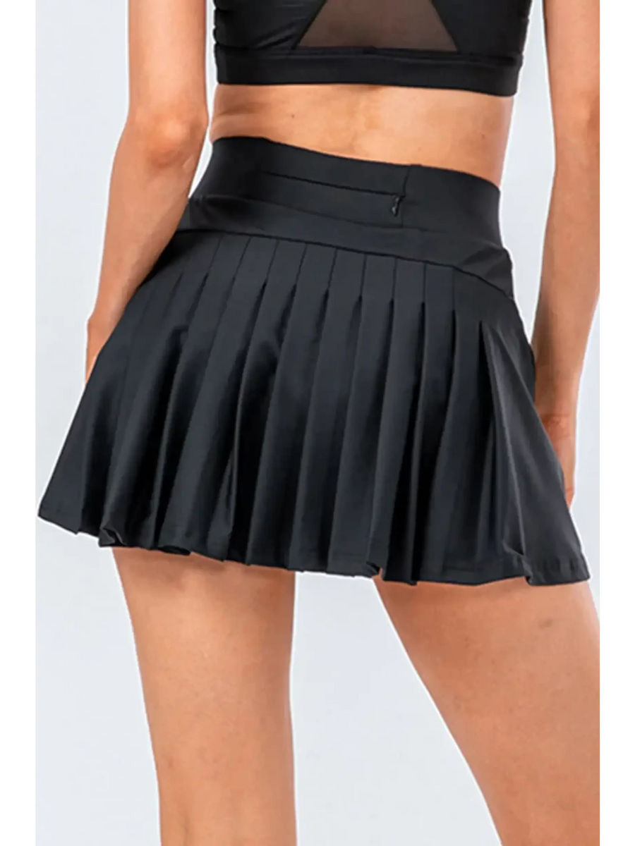 Babe Beachwear black pleated tennis skirt with pockets worn by model from the back