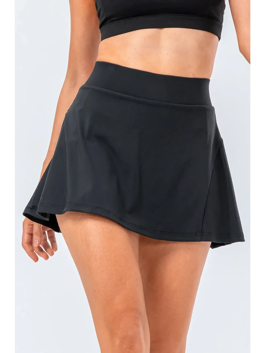 Babe Beachwear black pleated tennis skirt with pockets worn by model with crop top