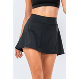 Babe Beachwear black pleated tennis skirt with pockets worn by model with crop top