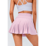 Babe Beachwaer pleated tennis skirt with pockets in light pink worn by model from the back
