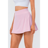Babe Beachwaer light pink pleated tennis skirt with pockets worn with white crop top
