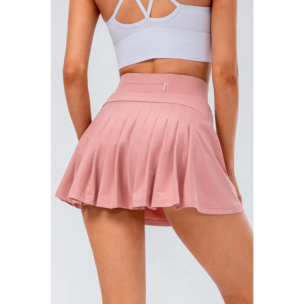 Babe Beachwear pleated tennis skirt with pockets in pink worn by woman from the back