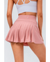 Babe Beachwear pleated tennis skirt with pockets in pink worn by woman from the back