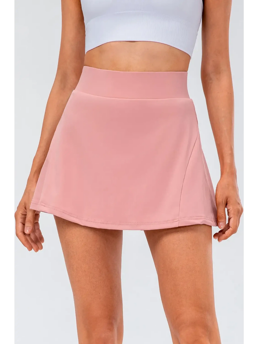 Babe Beachwear pleated tennis skirt with pockets in pink worn with white crop top