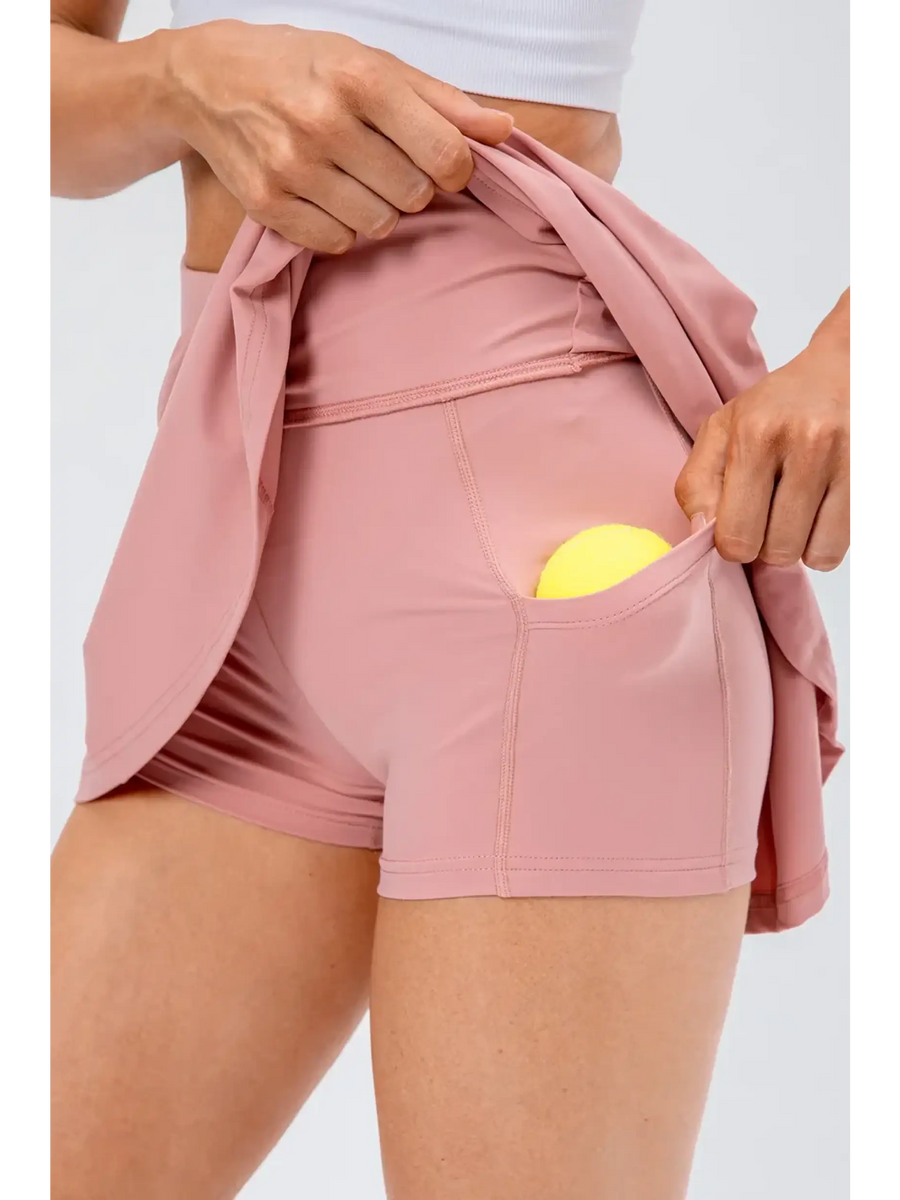 Babe Beachwear pleated tennis skirt with pockets in pink showing tennis ball pocket detail