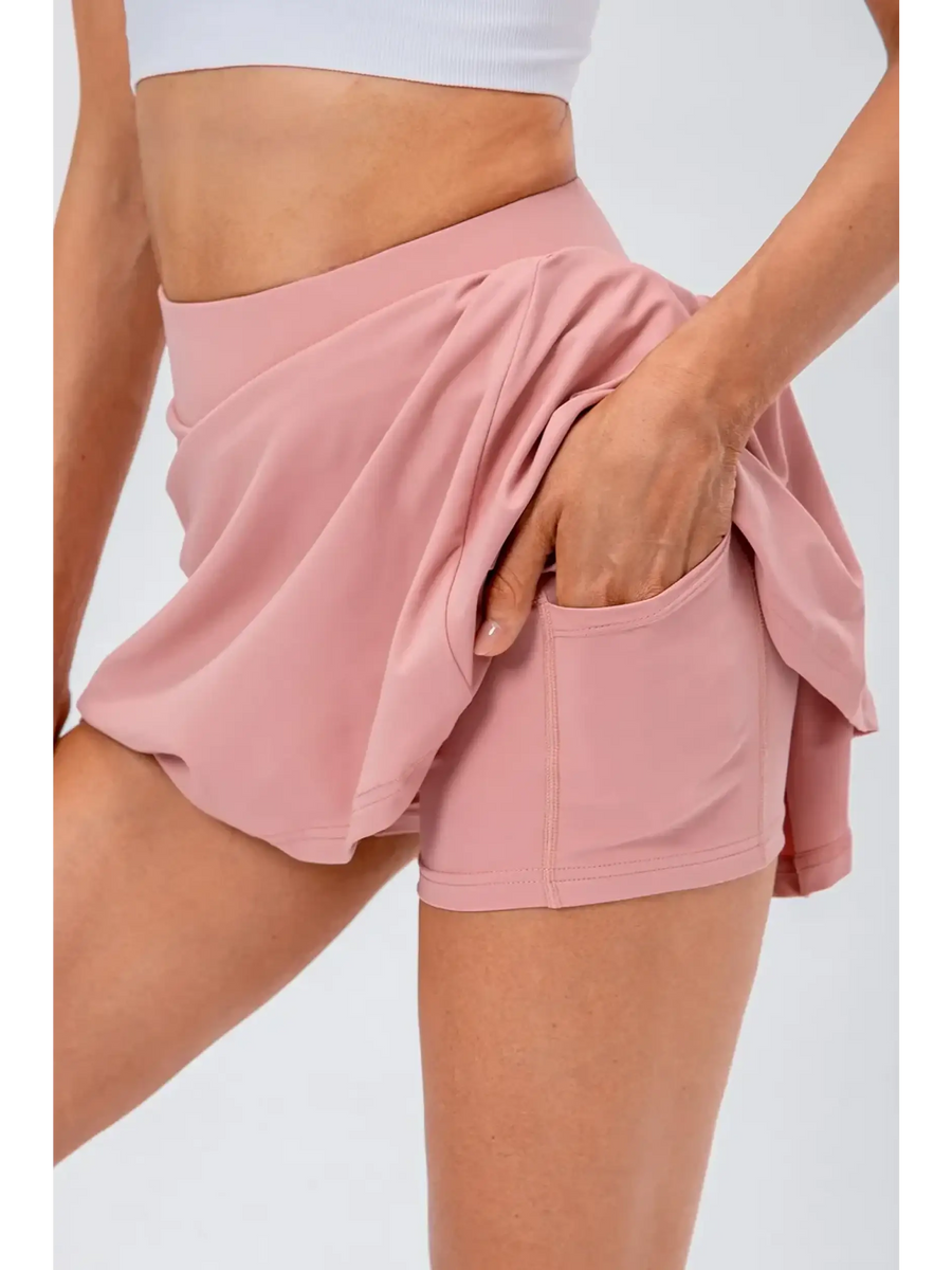 Babe Beachwear pleated tennis skirt with pockets in light pink, featuring built-in shorts and a high waistband