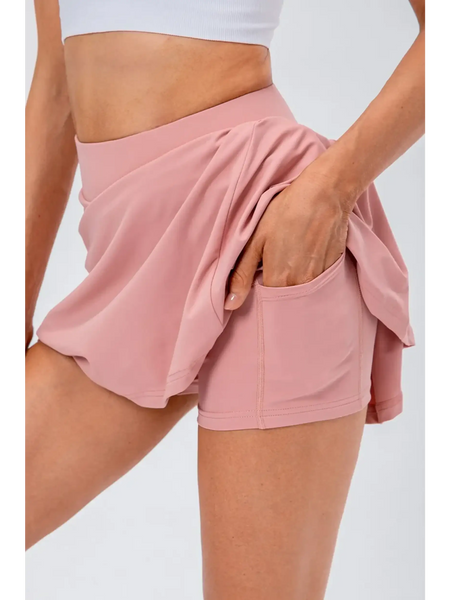 Babe Beachwear pleated tennis skirt with pockets in light pink, featuring built-in shorts and a high waistband