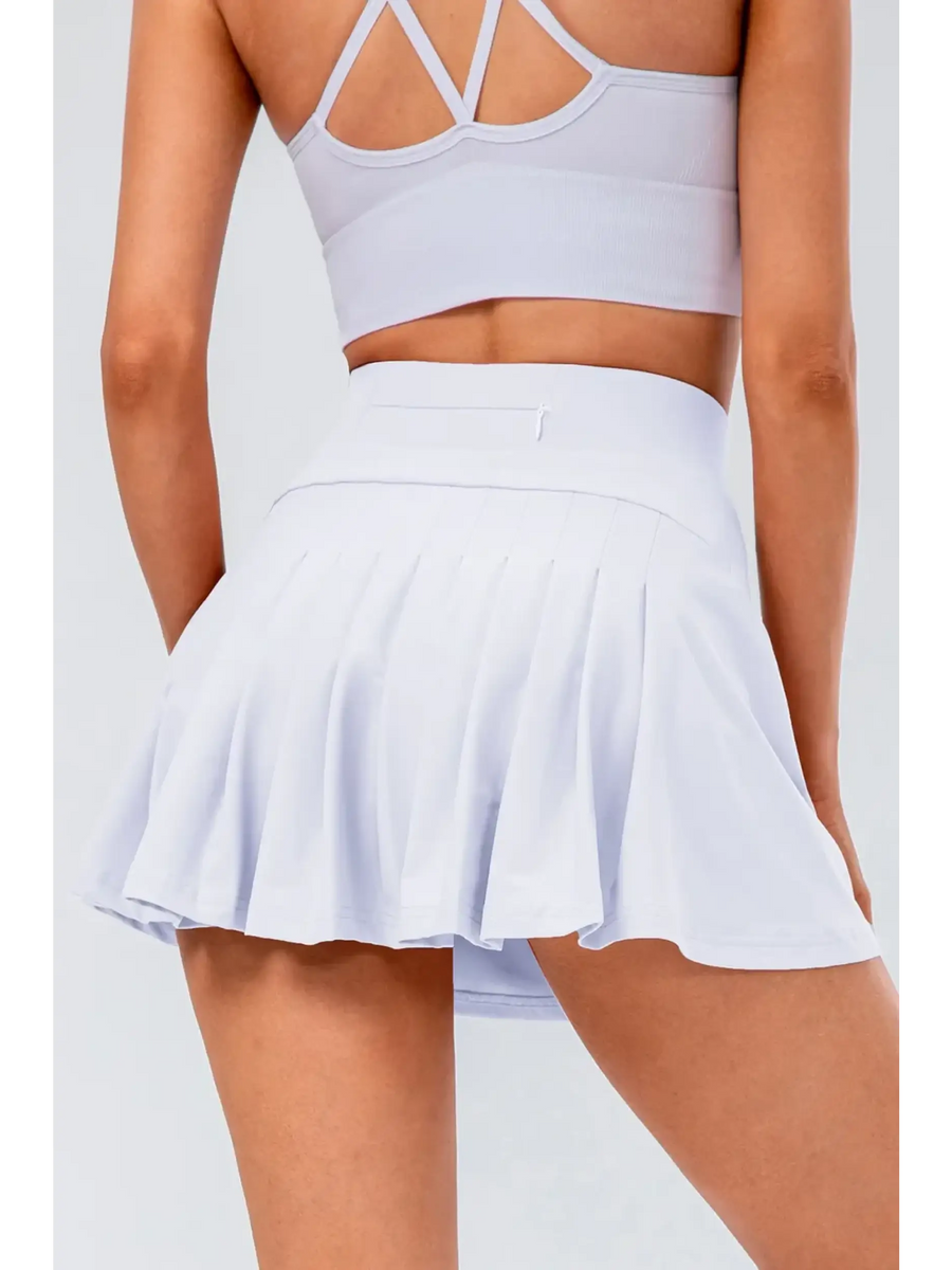 Babe Beachwear pleated tennis skirt with pockets in white worn from the back with a sports bra
