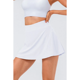White pleated tennis skirt with pockets by Babe Beachwear worn with a white crop top