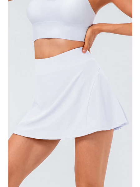 White pleated tennis skirt with pockets by Babe Beachwear worn with a white crop top