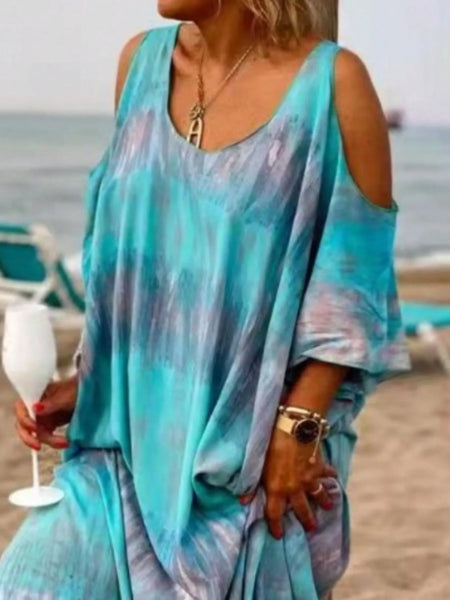 Trendsi plus size tie dye maxi dress with cold shoulder design in blue and purple hues worn at the beach