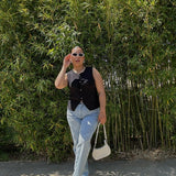 Woman wearing Babe Beachwear chic metallic flat slip-ons with light blue jeans and black sleeveless top