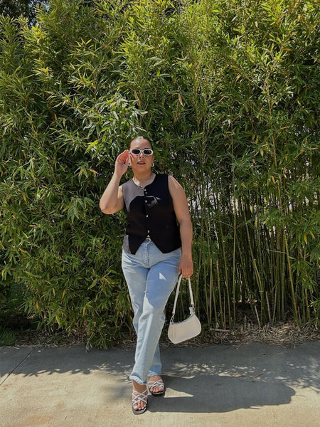 Woman wearing Babe Beachwear chic metallic flat slip-ons with light blue jeans and black sleeveless top