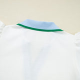 Back view of EG fashion white sleeveless ruffle sleeve beach blouse with blue and green collar detail