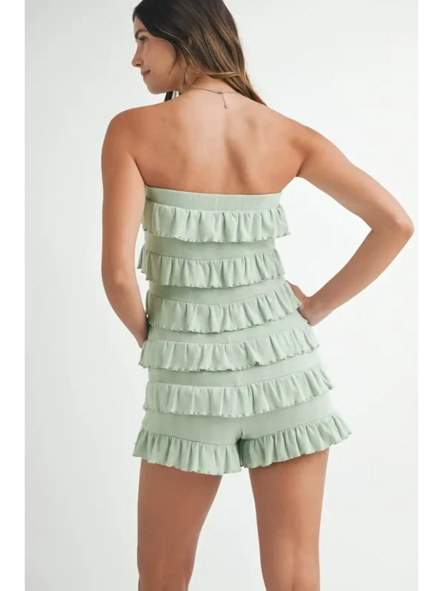Trendsi light green ruffled tube romper with tiered ruffle details worn by a woman from back