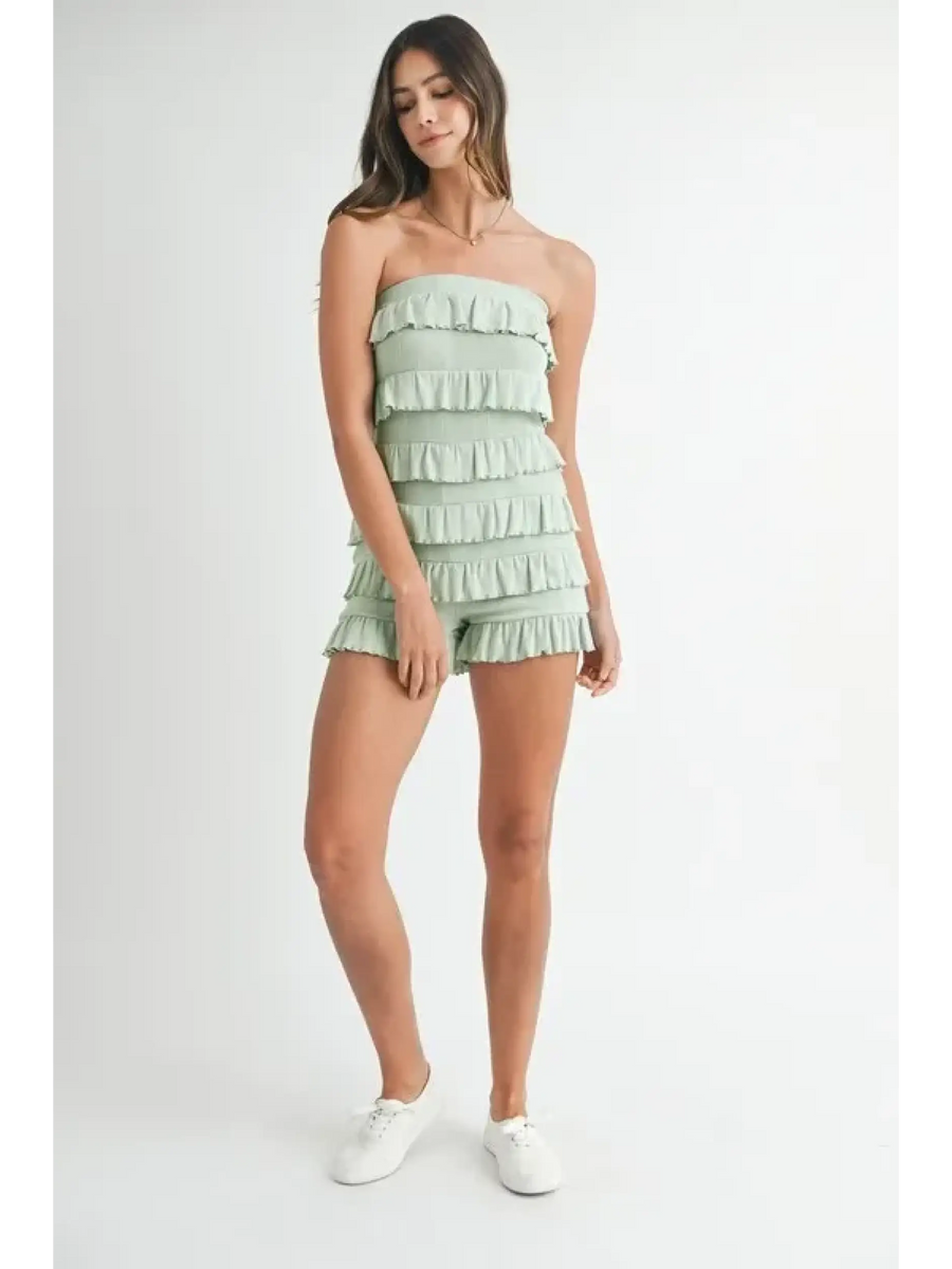 Trendsi model wearing a light green ruffled tube romper with multiple layered ruffles and white sneakers