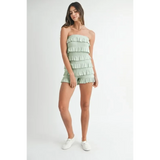 Trendsi model wearing a light green ruffled tube romper with multiple layered ruffles and white sneakers