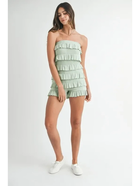 Trendsi model wearing a light green ruffled tube romper with multiple layered ruffles and white sneakers