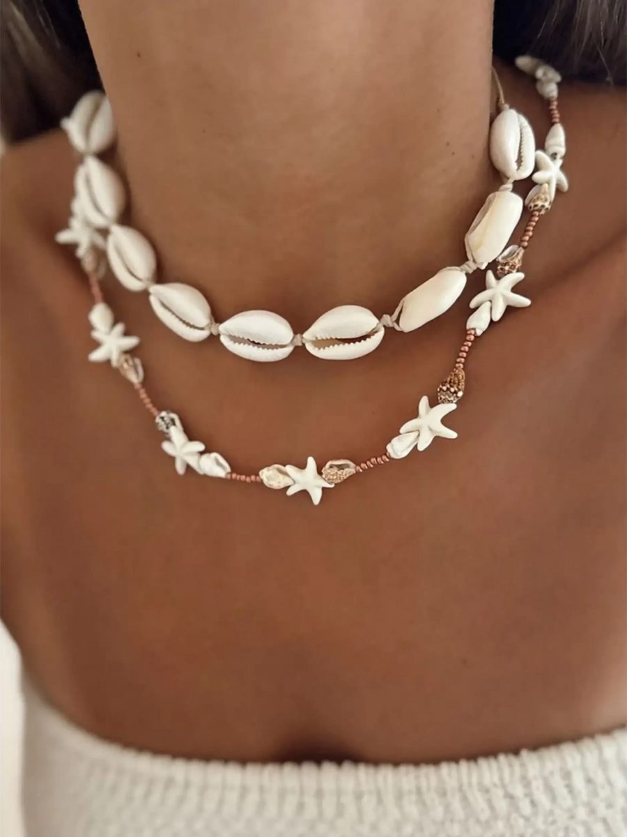 Seashell layered necklace for beach featuring white shell and starfish designs on a model's neck