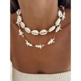 Seashell layered necklace for beach featuring white shell and starfish designs on a model's neck