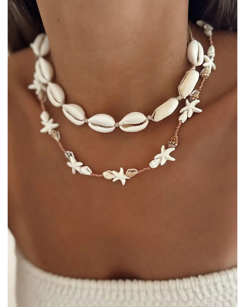 Seashell layered necklace for beach featuring white shell and starfish designs on a model's neck