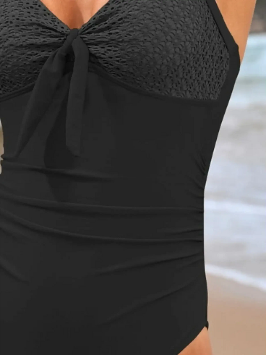 Beach Babes black sexy one-piece bathing suit with textured bust and tie detail at the beach