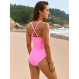 Beach Babes sexy one-piece bathing suit in pink with crisscross back straps on beach model